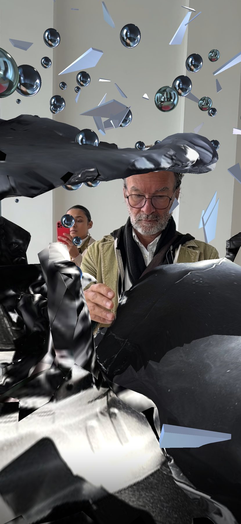Encounter AR view: a bearded visitor studies the crumpled black wreckage with a red-cased phone, mirrored spheres overhead.